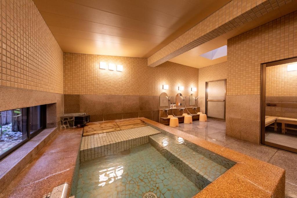 - une grande piscine dans un bâtiment avec piscine dans l'établissement Mori no Nanakusa, à Munakata