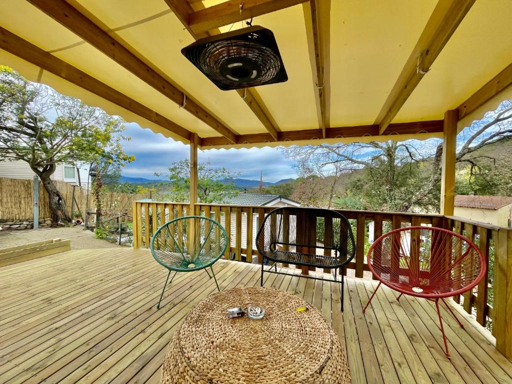 2 chaises et une table sur une terrasse dans l'établissement Mobil home climatisé golf de saint tropez camping 4 étoile, à Gassin