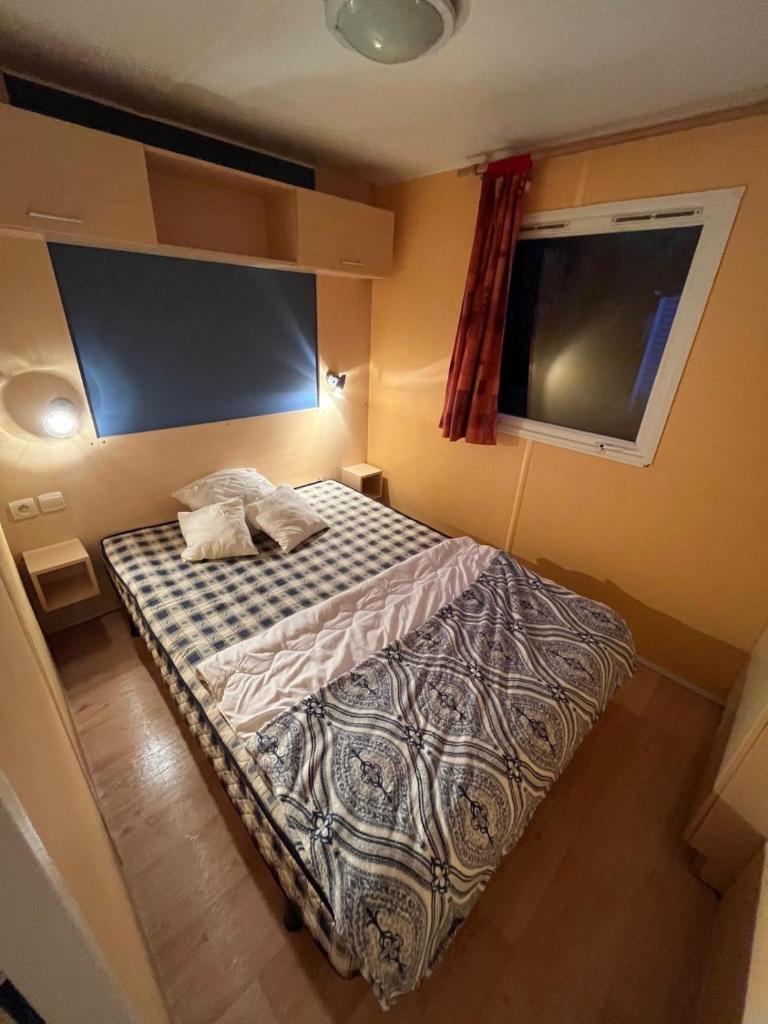une petite chambre avec un lit dans une pièce dans l'établissement Mobil-Home avec belle exposition, à Saint-Chéron