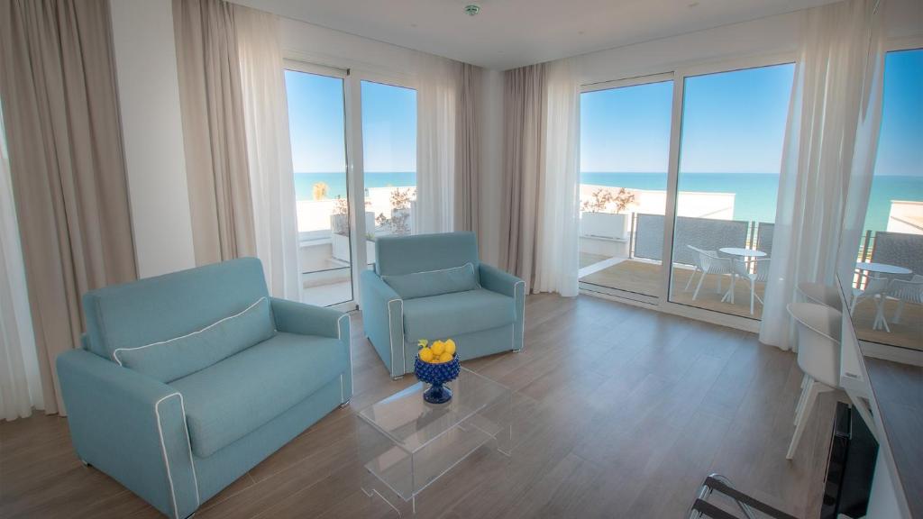 - deux chaises bleues dans le salon avec vue sur l'océan dans l'établissement Rodi Resort, à Rodi Garganico