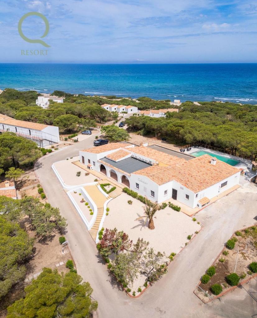 Vue aérienne d'une maison avec l'océan en arrière-plan dans l'établissement Q Resort, à Marina di Sorso