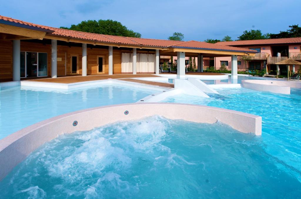 une grande piscine devant un immeuble dans l'établissement Green Village Eco Resort, à Lignano Sabbiadoro