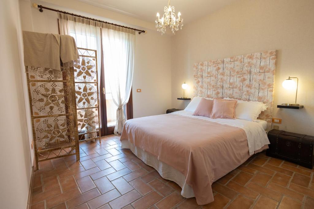 une chambre avec un grand lit et un lustre dans l'établissement Villa Stephanie, à Marina di Ragusa