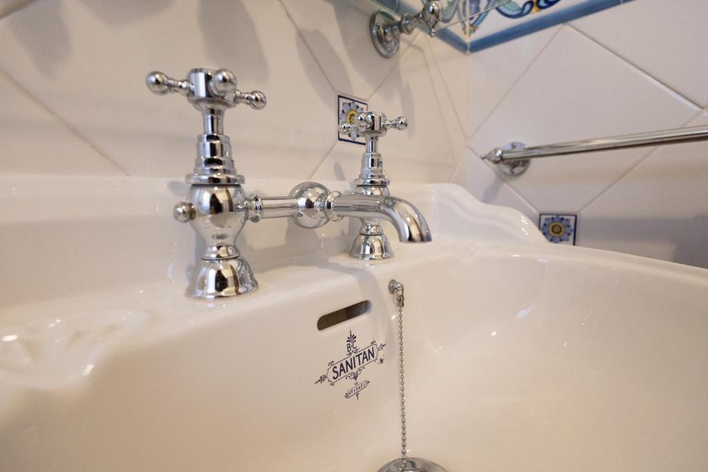 - un lavabo blanc avec deux robinets dans la salle de bains dans l'établissement Villa Stephanie, à Marina di Ragusa