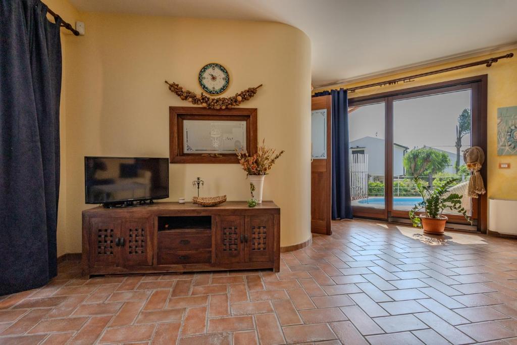 - un salon avec une télévision à écran plat sur une armoire en bois dans l'établissement Villa Stephanie, à Marina di Ragusa