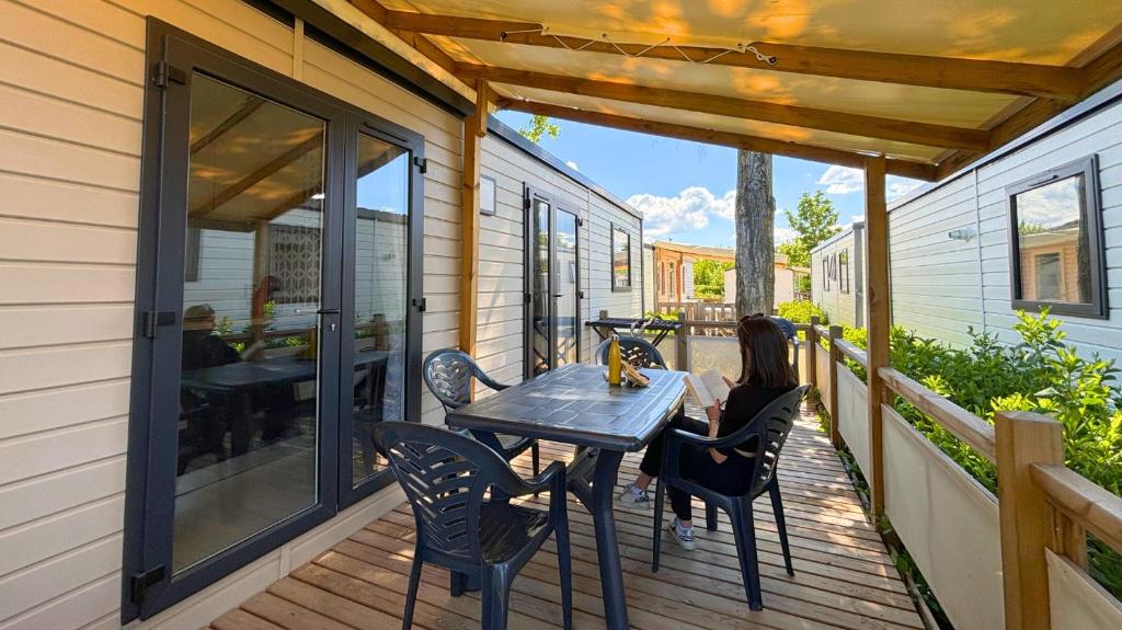 un patio avec une table et des chaises sur une terrasse dans l'établissement Camping Tikayan L'Oxygène, à Valensole