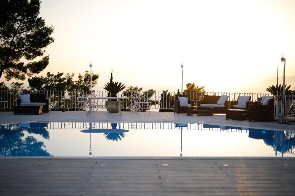 une piscine avec des canapés et des chaises autour dans l'établissement Villa con piscina con 8 camere matrimoniali ad Anacapri, by La Canostra Capri, à Anacapri