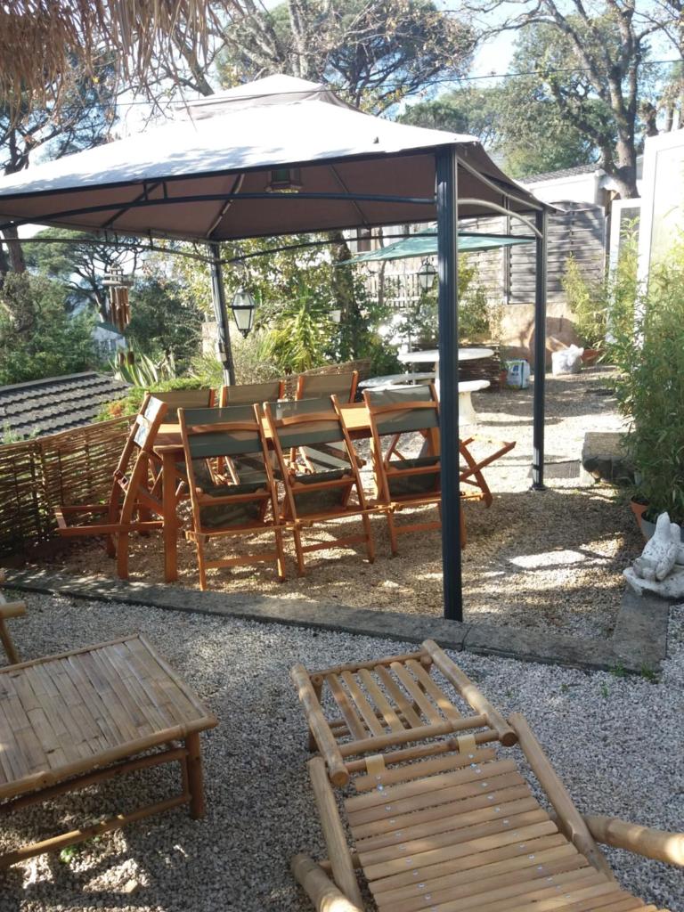 - une table de pique-nique et des chaises sous un parasol dans l'établissement SAS CAMPING PARC MONTANA, à Gassin 3 autres photos