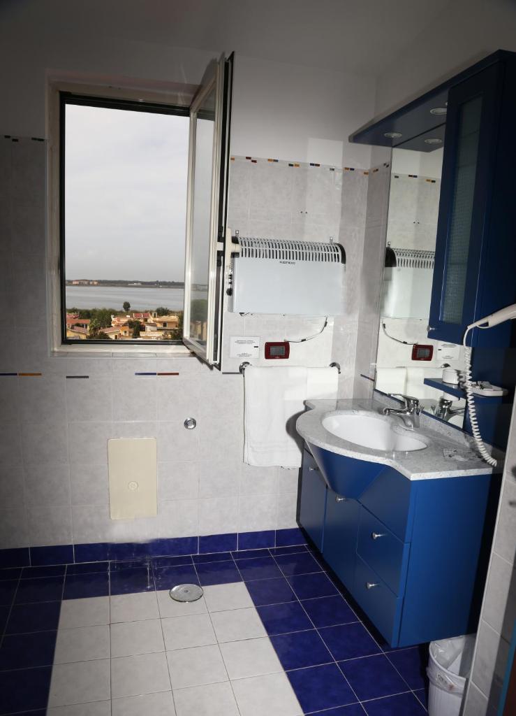 une salle de bain avec un lavabo et une fenêtre dans l'établissement Hotel Resort Il Panfilo, à Lago Patria