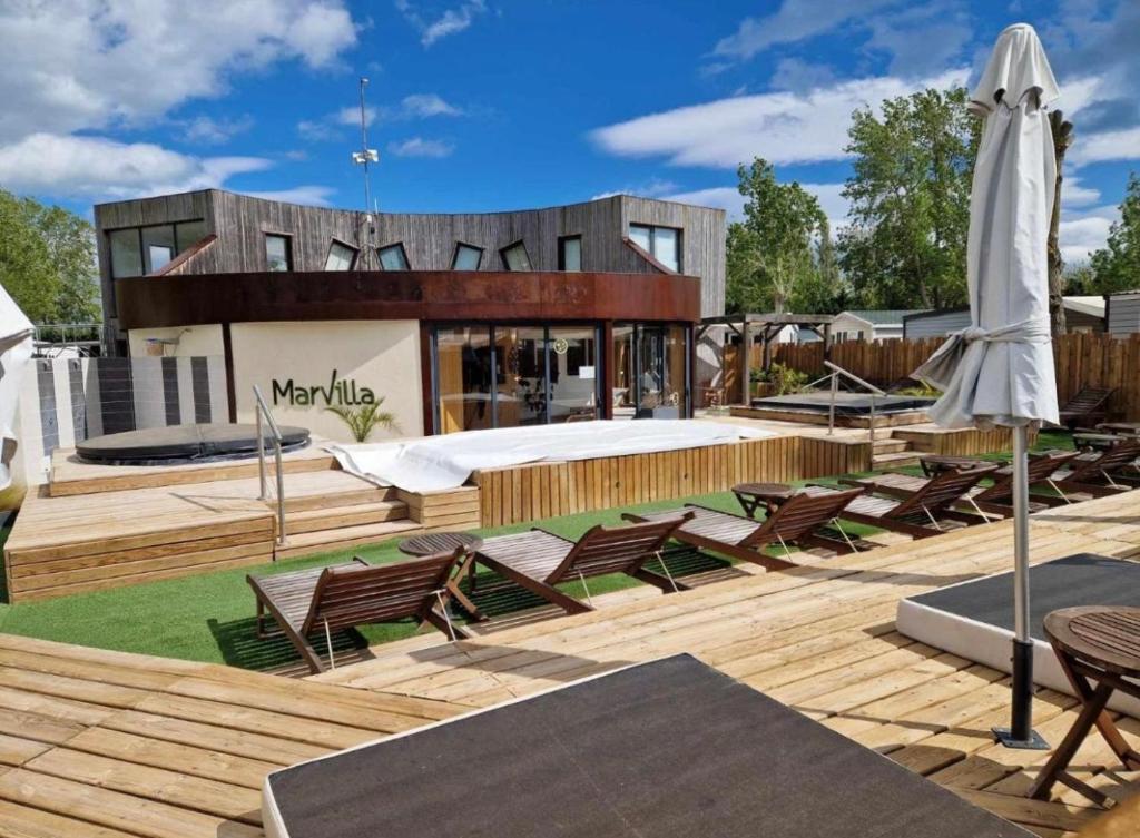 un patio avec des chaises, un matelas et un parasol dans l'établissement CAMPING VALRAS PLAGE 5 ETOILES, à Vendres