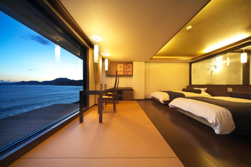 une chambre avec deux lits et une vue sur l'océan dans l'établissement Senoumi, à Higashiizu