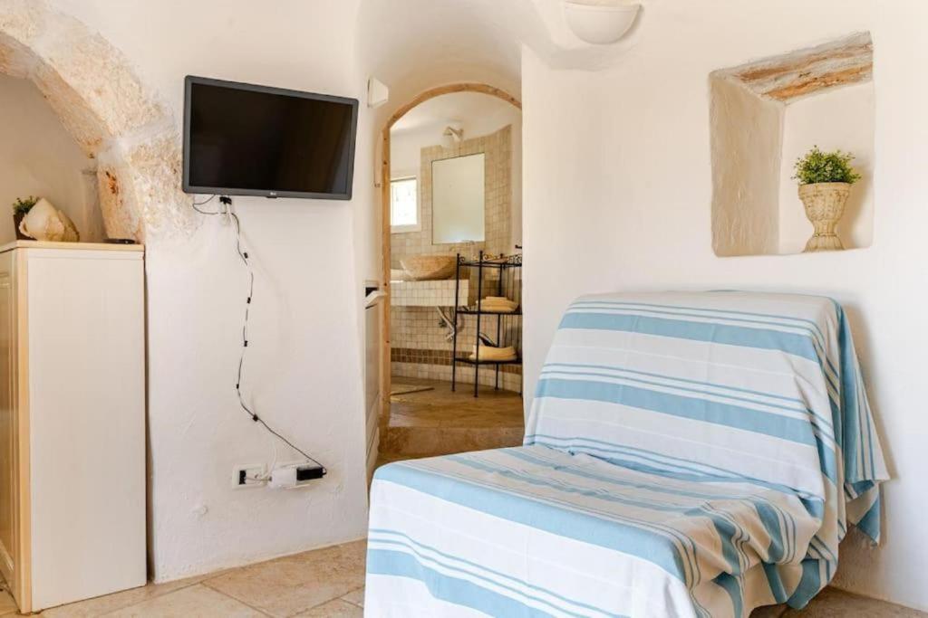 une chambre avec un lit et une télévision sur un mur dans l'établissement Trullo Vittoria Ostuni with private swimming pool, à Ostuni 22 autres photos