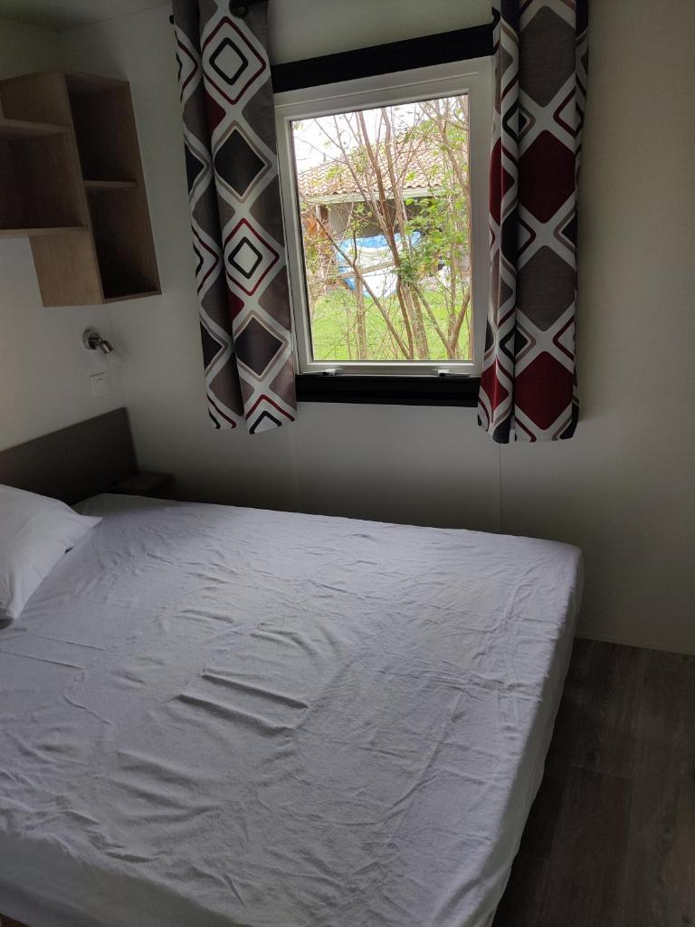 une chambre avec un lit et une fenêtre dans l'établissement Frédéric et Maëva, à Saint-Julien-en-Born