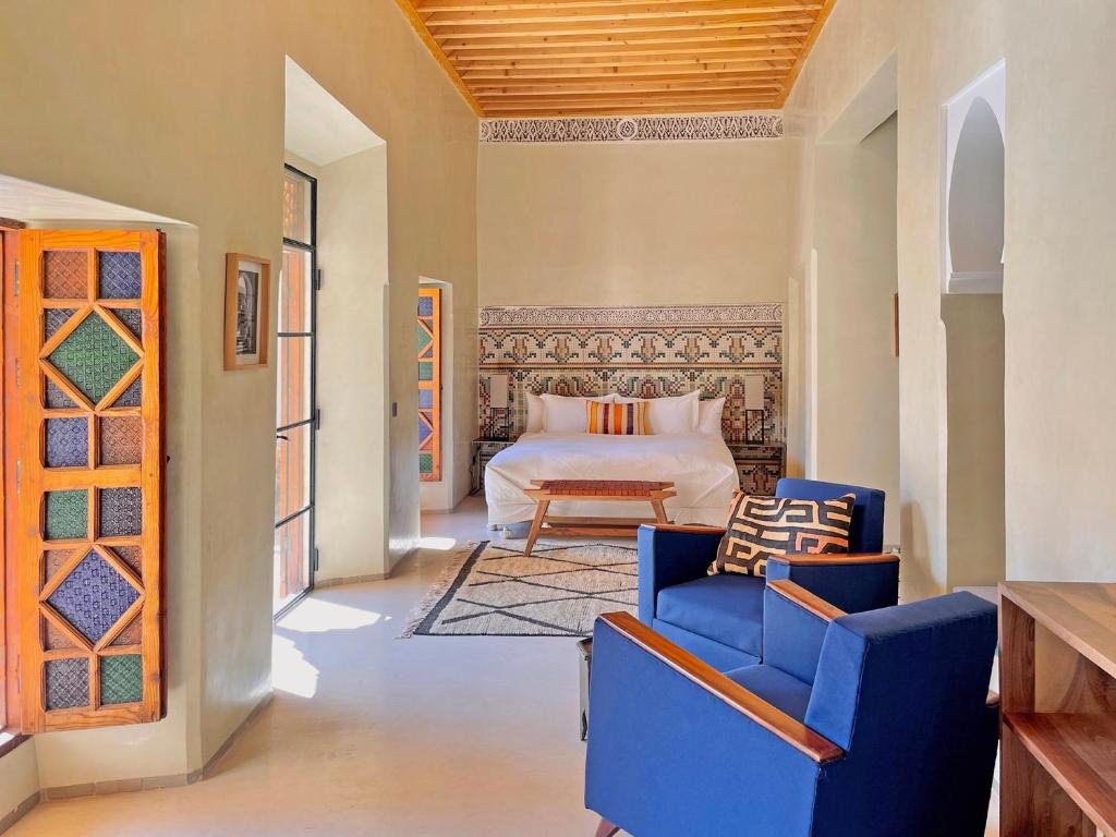 - une chambre avec un lit et deux chaises bleues dans l'établissement Riyad Lion Rouge, à Marrakech 37 autres photos