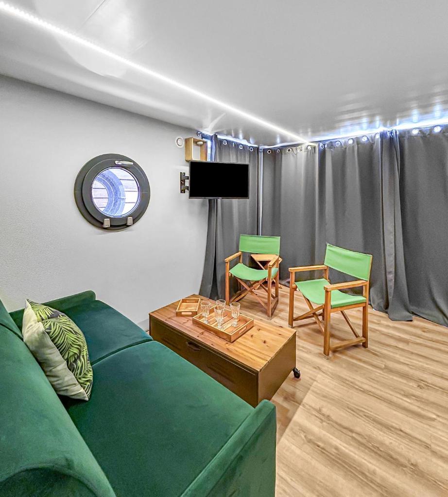 - un salon avec un canapé vert et 2 chaises dans l'établissement Bord du Canal du Rhône à Sète sur "César", à Vauvert