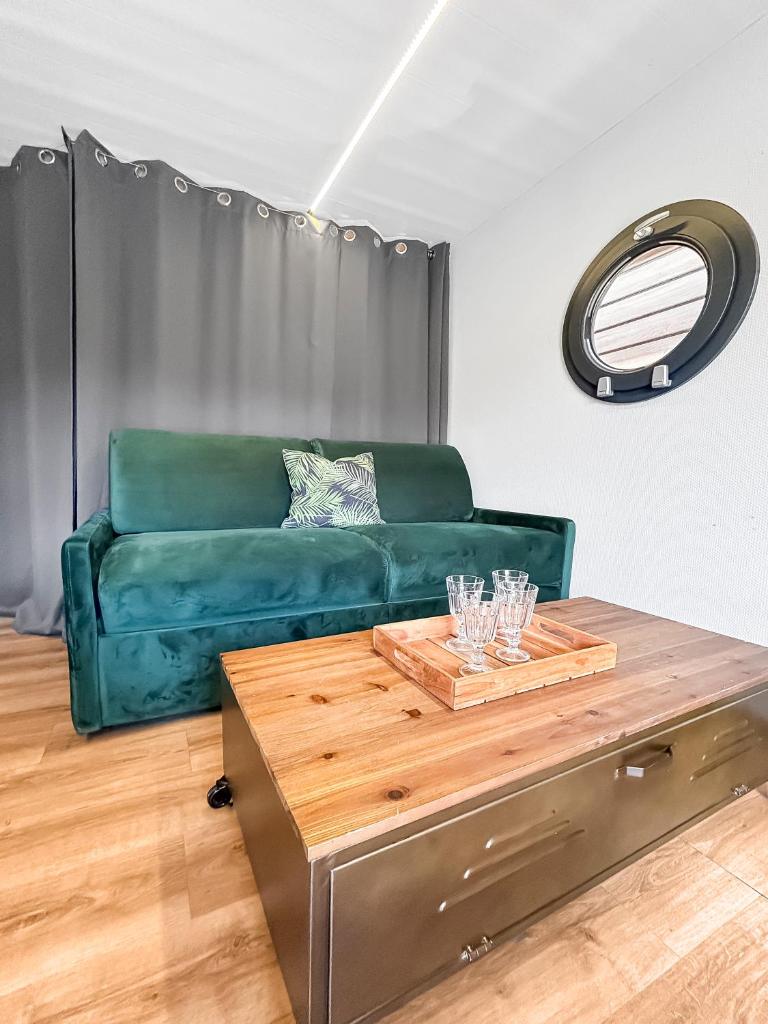 un salon avec un canapé vert et une table dans l'établissement Bord du Canal du Rhône à Sète sur "César", à Vauvert 21 autres photos