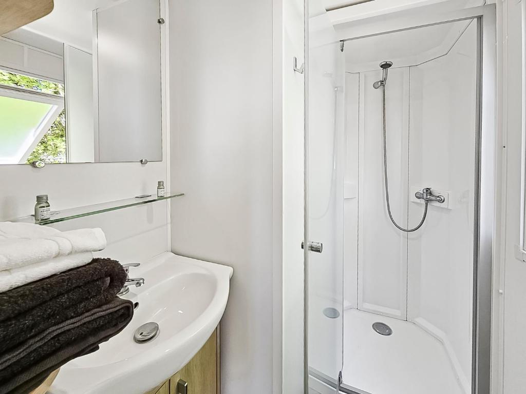 une salle de bain blanche avec une douche et un lavabo dans l'établissement Evasion Normande, à Litteau