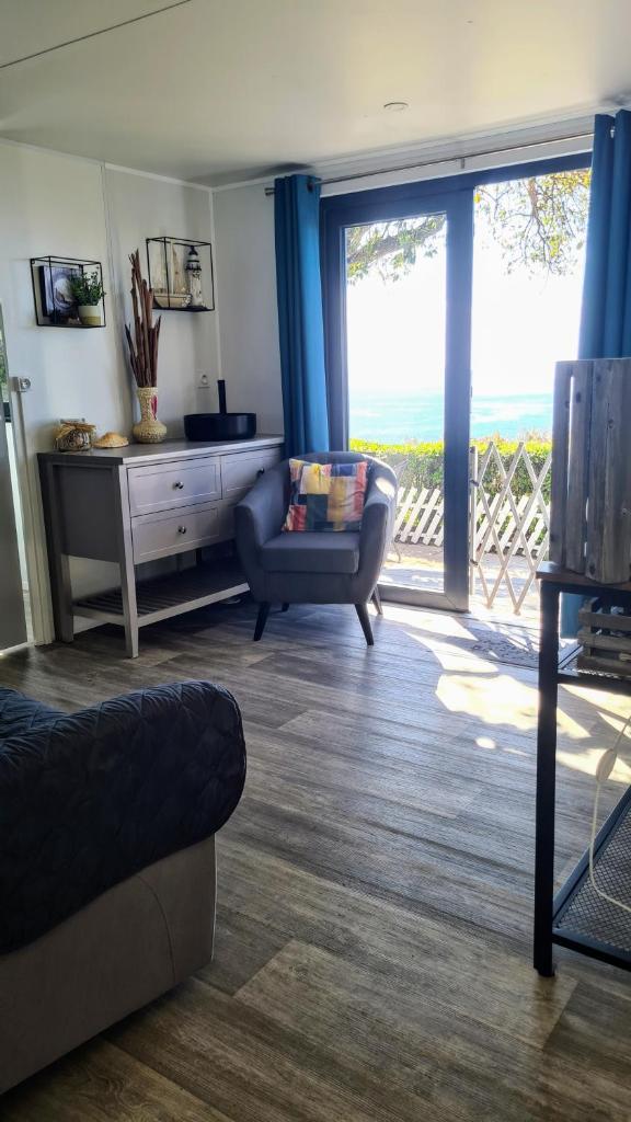 un salon avec un canapé et une chaise dans l'établissement Au Petit Paradis, à Saint-Raphaël