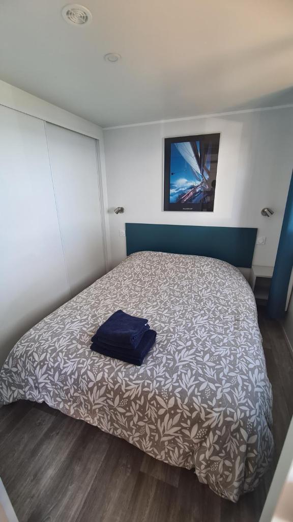 une chambre avec un lit avec un oreiller bleu dessus dans l'établissement Au Petit Paradis, à Saint-Raphaël