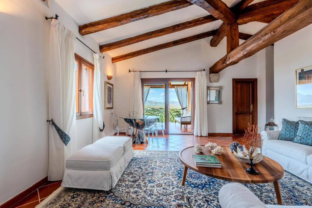 un salon avec un canapé blanc et une table dans l'établissement Villa Capo Coda Cavallo piscina privata, à San Teodoro