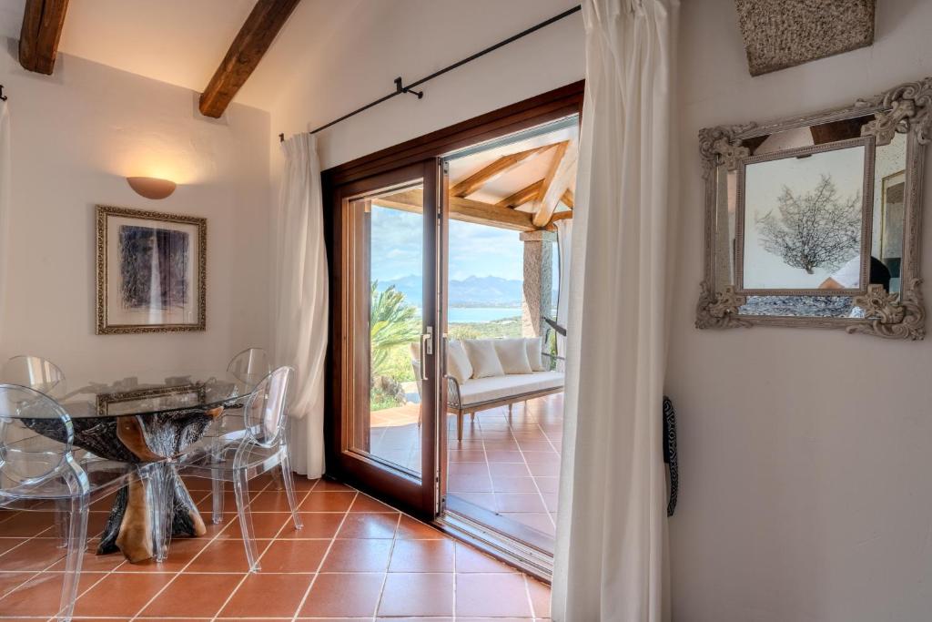 Cette chambre dispose d'une porte menant à une terrasse. dans l'établissement Villa Capo Coda Cavallo piscina privata, à San Teodoro