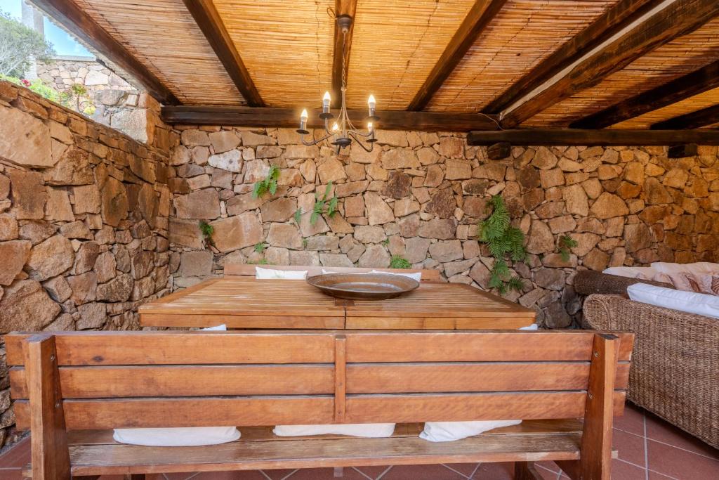 une pièce avec une table en bois et un banc dans l'établissement Villa Capo Coda Cavallo piscina privata, à San Teodoro