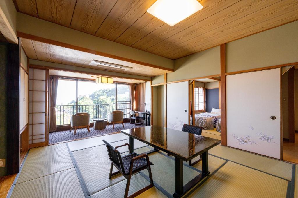 Cette chambre dispose d'une table, de chaises et d'un balcon. dans l'établissement Atagawa Prince Hotel, à Higashiizu