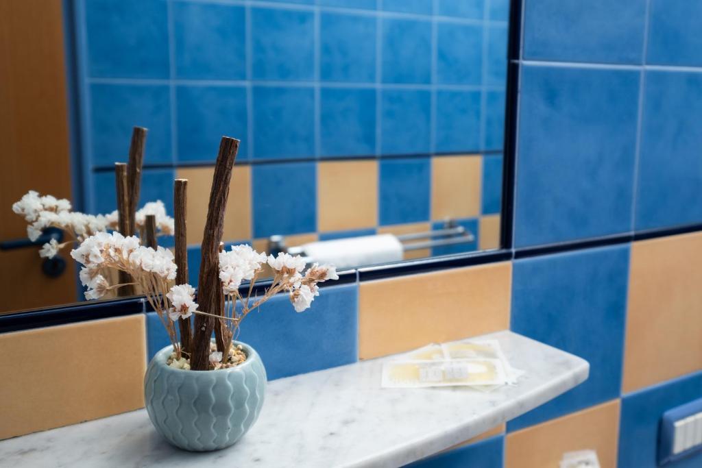 un vase avec des fleurs sur un comptoir dans une salle de bain dans l'établissement Oasi Azzurra, à Messina