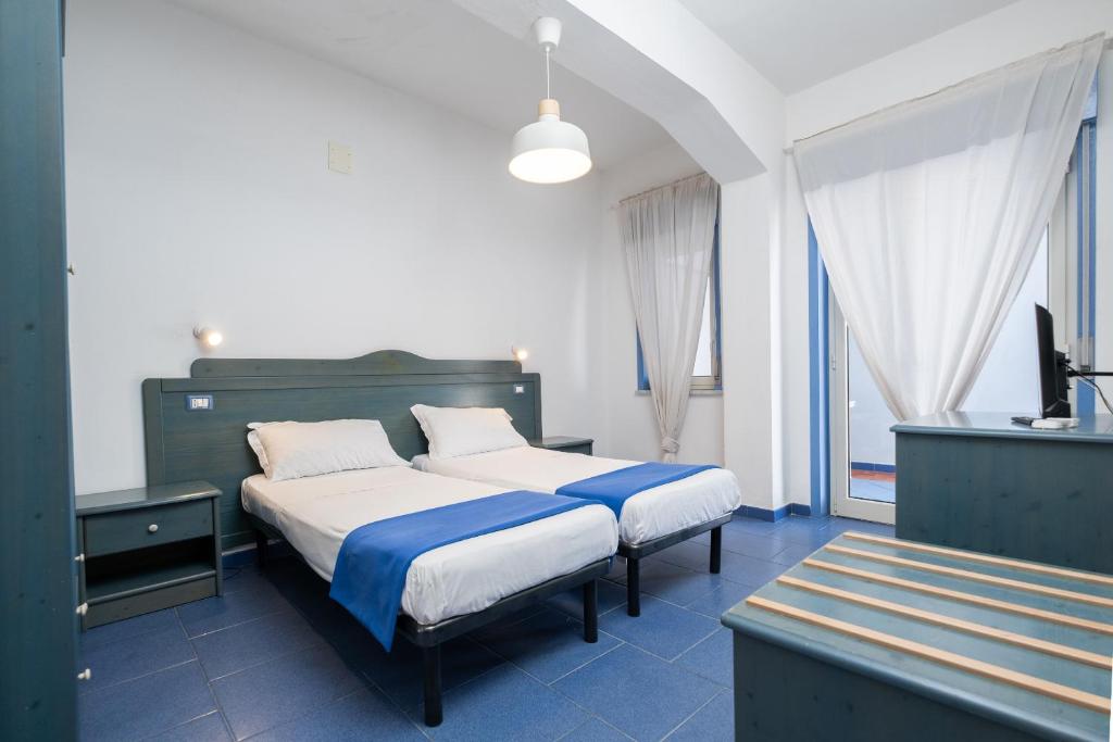 une chambre avec un grand lit avec des draps bleus et blancs dans l'établissement Oasi Azzurra, à Messina 50 autres photos