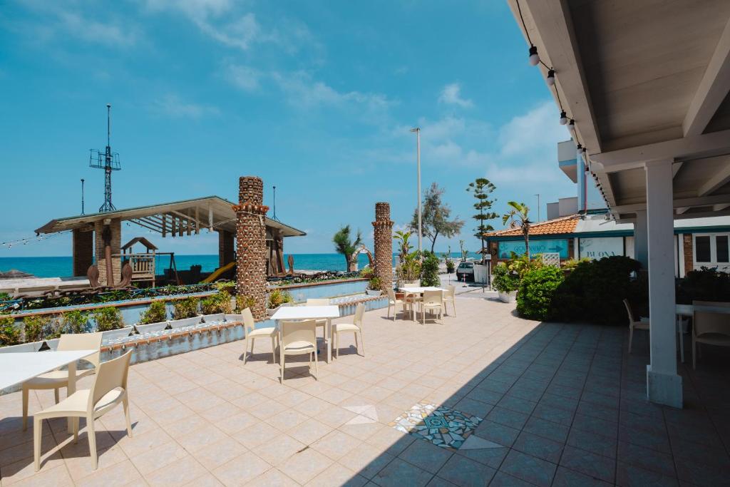 d'une terrasse avec des tables et des chaises à côté de l'océan. dans l'établissement Oasi Azzurra, à Messina