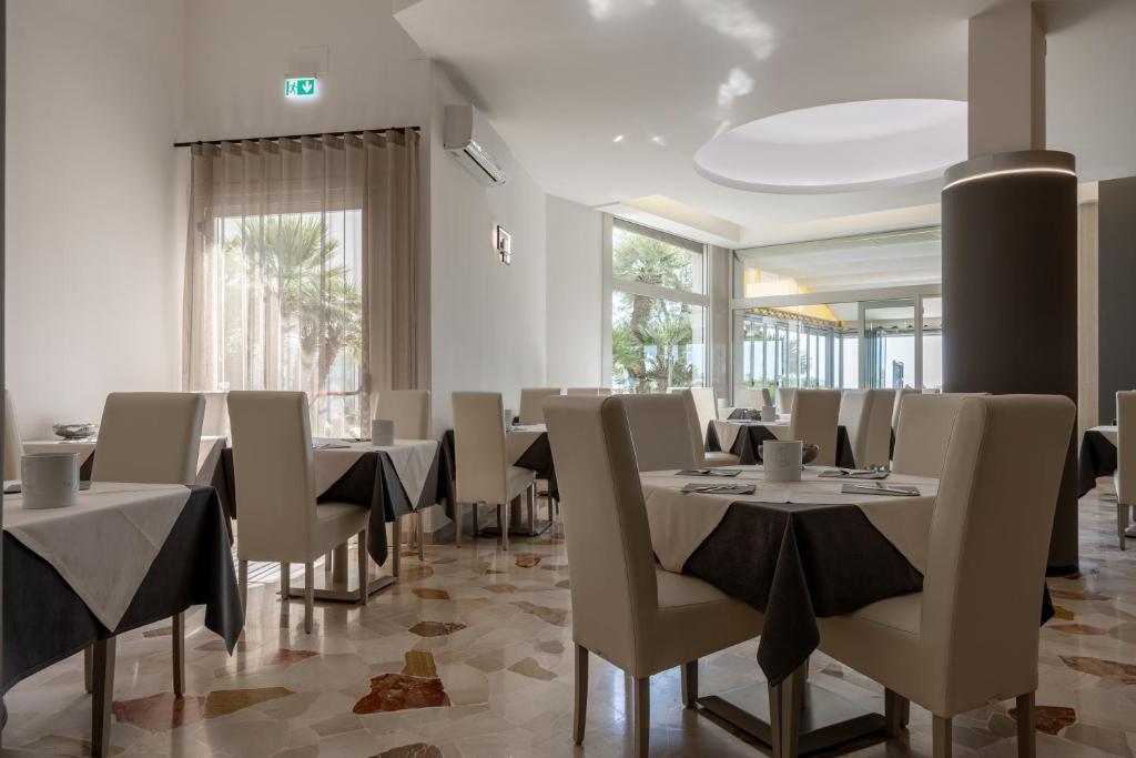 une salle à manger avec des tables et des chaises dans un restaurant dans l'établissement Hotel Continental, à Caorle