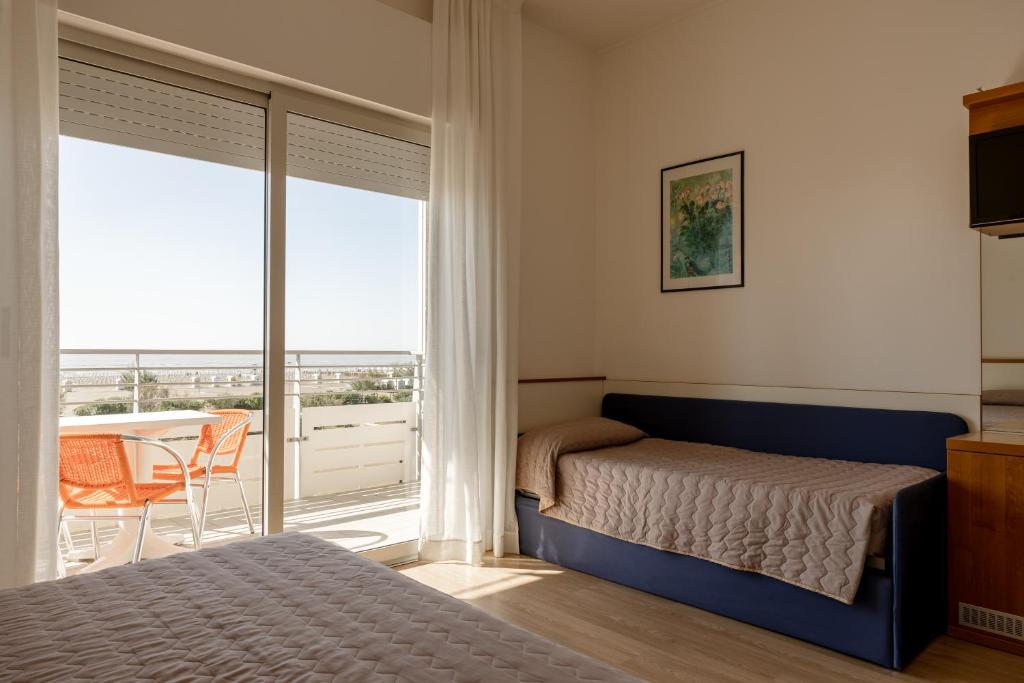 une chambre avec un lit et un balcon dans l'établissement Hotel Continental, à Caorle