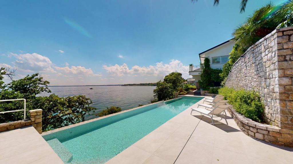 une piscine avec vue sur l'eau dans l'établissement Villa Flora, à Manerba del Garda
