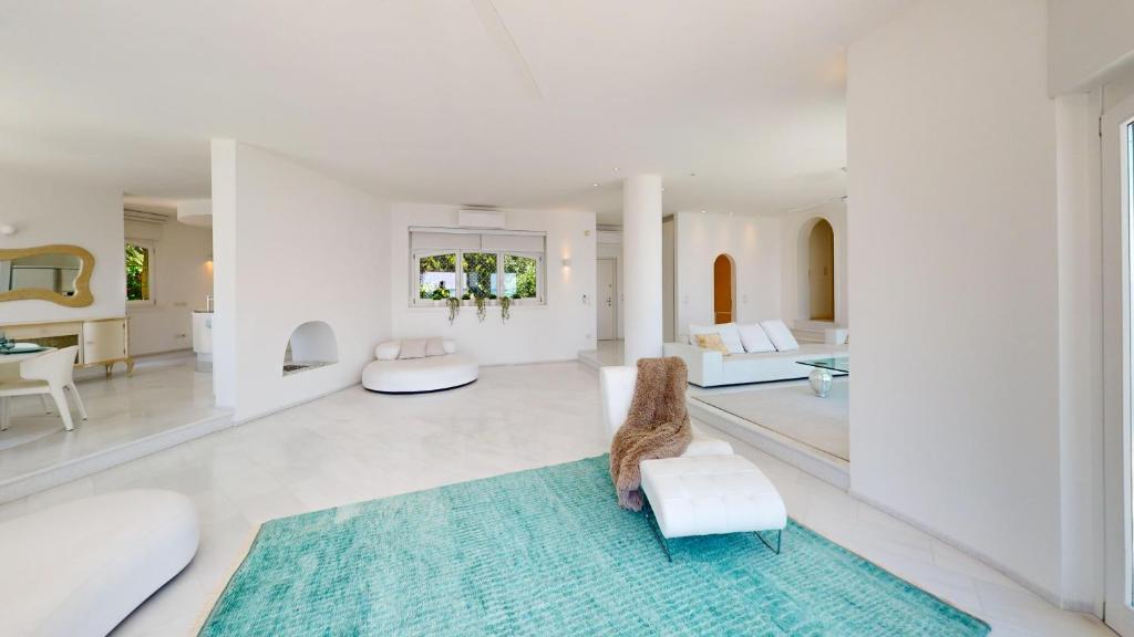 - un salon doté d'un mobilier blanc et d'un tapis bleu dans l'établissement Villa Flora, à Manerba del Garda