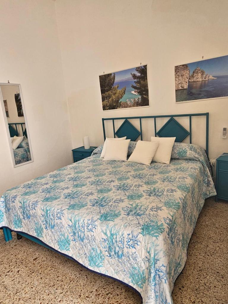 une chambre avec un lit avec un couvre-lit bleu et blanc dans l'établissement Corso's old nest a mille metri dalla spiaggia guida loca, à Castellammare del Golfo 66 autres photos