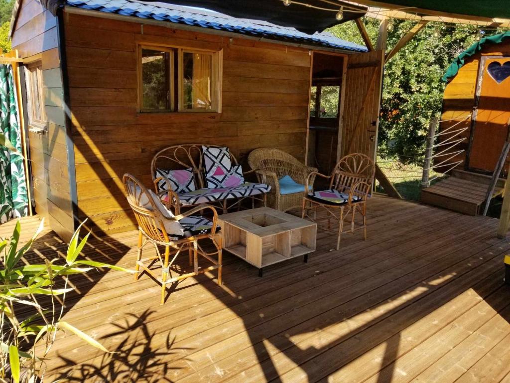 une véranda avec des chaises et une table dans l'établissement La Tiny-house et la roulotte des sables, à Le Porge