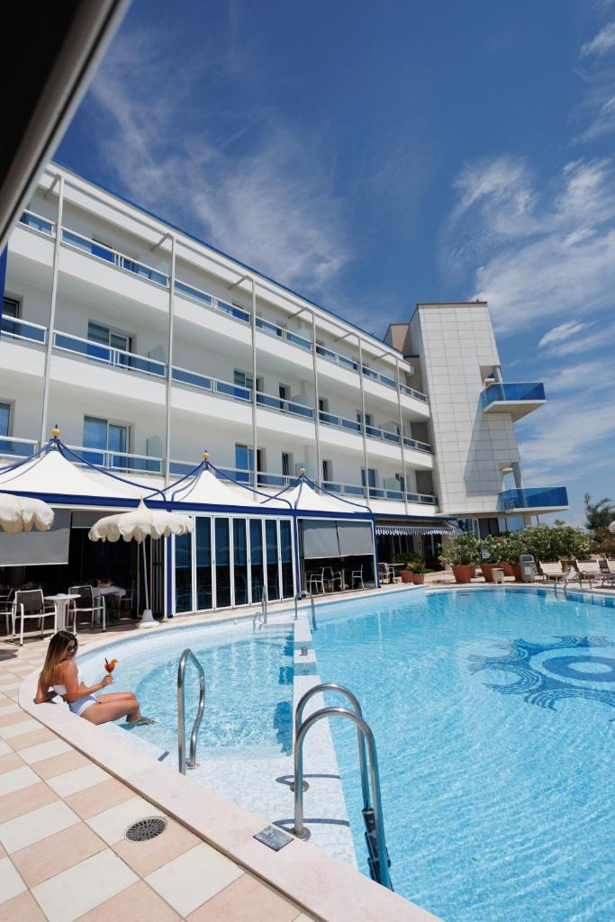 une femme allongée dans une piscine devant un hôtel dans l'établissement Hotel Panoramic, à Caorle