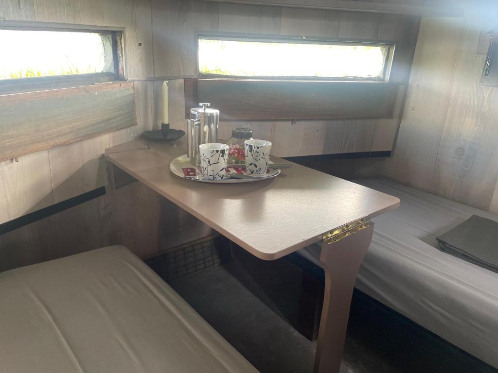 une petite table dans une petite pièce avec des tasses dessus dans l'établissement Nature en Somme, à Quend