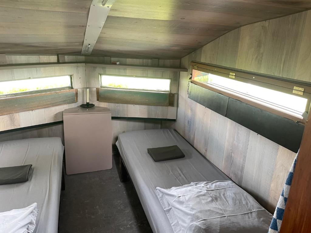Cette petite chambre comprend 2 lits et 2 fenêtres. dans l'établissement Nature en Somme, à Quend