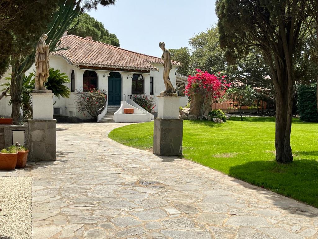une maison avec des statues devant une allée dans l'établissement Historic Villa Giardini, Pool and Private Park, à Capoterra 47 autres photos