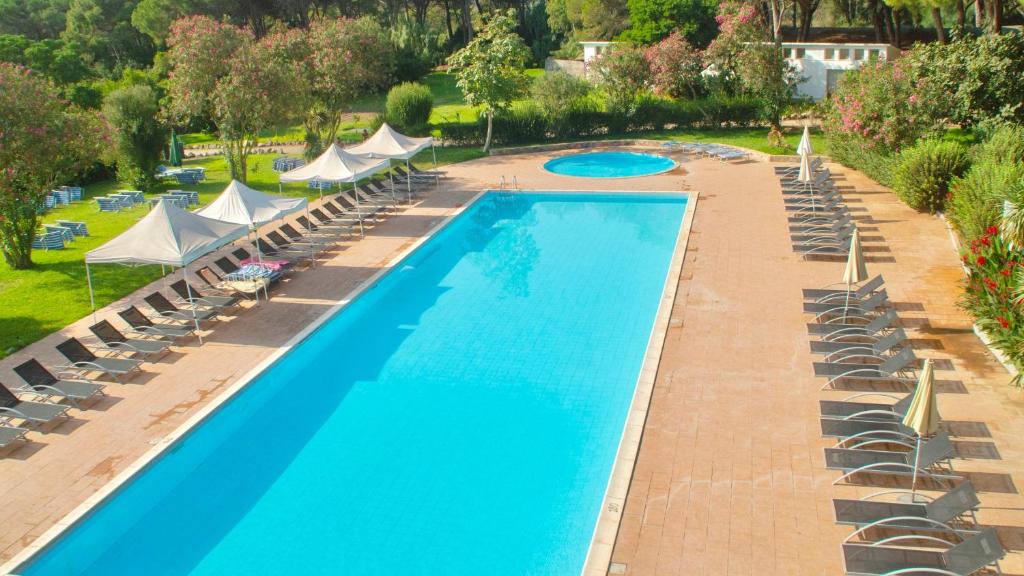 une vue aérienne d'une piscine avec chaises et parasols dans l'établissement Residence with swimming-pool in Arborea just 300 meters from the beach, à Arborea