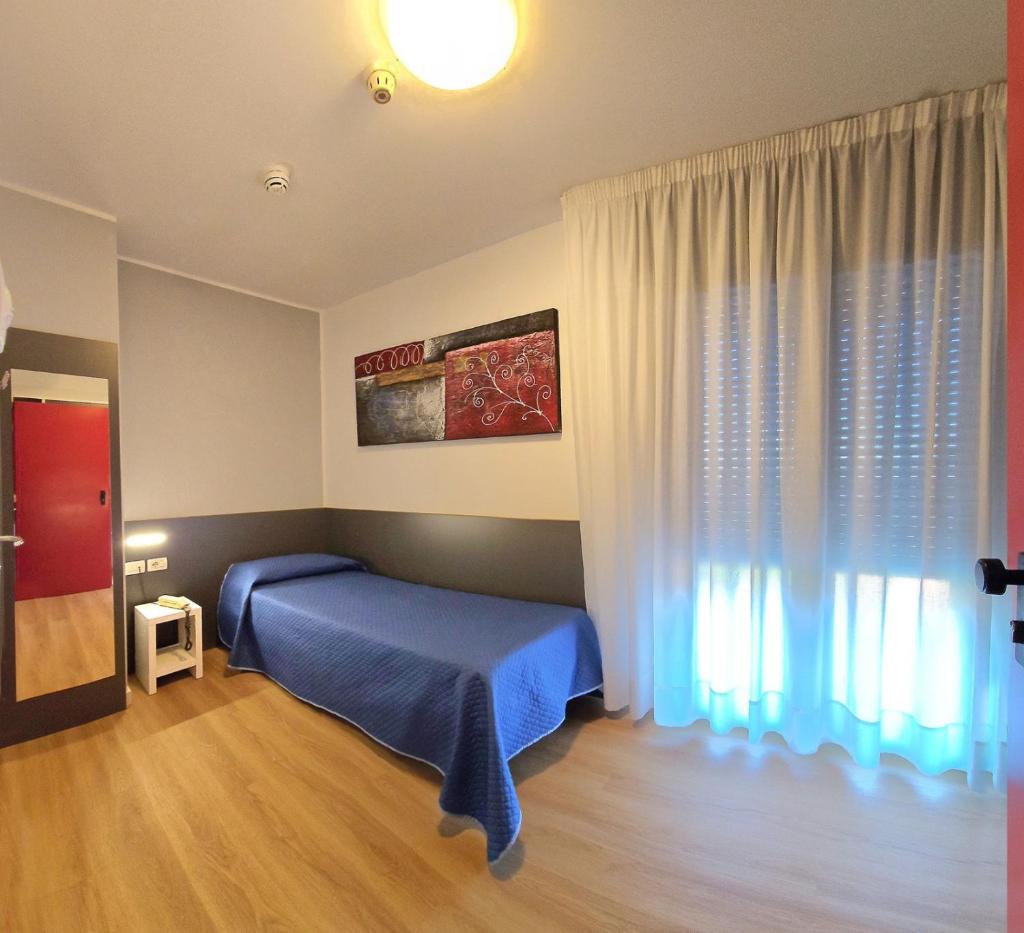 une chambre avec un lit bleu et une fenêtre dans l'établissement Hotel Panorama, à Lido di Jesolo