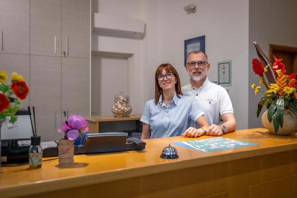 un homme et une femme assis à un bureau dans l'établissement Mareblù - Tuscany Green Aparthotel, à Principina a Mare 46 autres photos