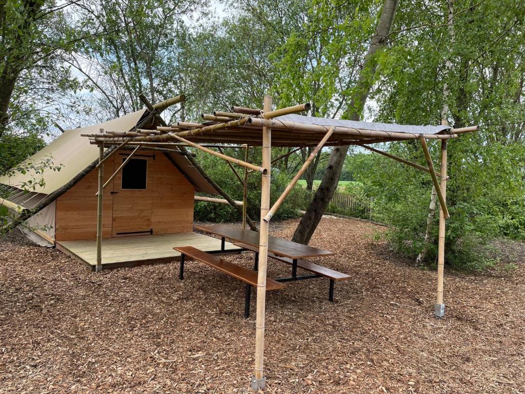 un abri en bois avec une table de pique-nique devant dans l'établissement Camp du Père Castor, à Simard 13 autres photos