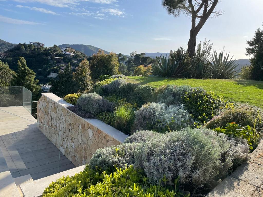 un jardin avec un mur de conservation et des plantes dans l'établissement Villa with private pool, amazing sea panorama and private garden, à Domus de Maria