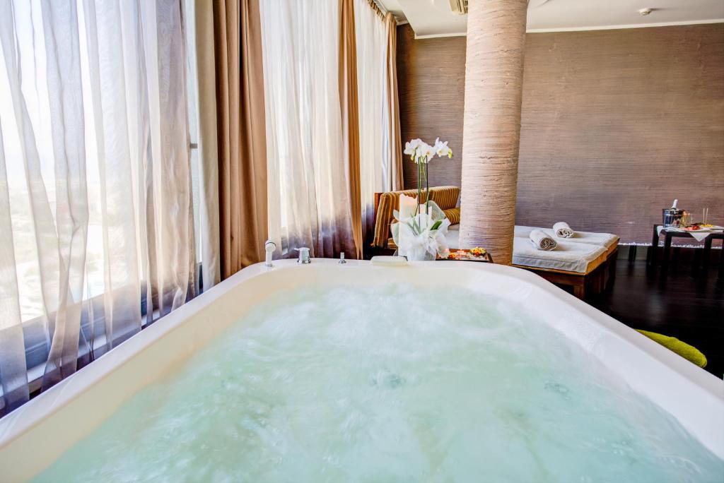 Cette chambre comprend une salle de bains pourvue d'une grande baignoire. dans l'établissement Hotel Le Palme - Premier Resort, à Milano Marittima