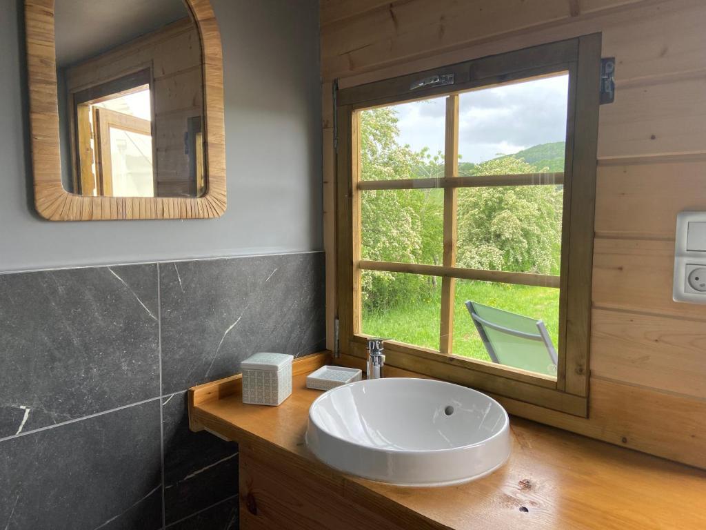 une salle de bain avec un lavabo et une grande fenêtre dans l'établissement Nuit insolite en Tipi avec bain nordique privatif, petits déjeuners inclus, à Médonville
