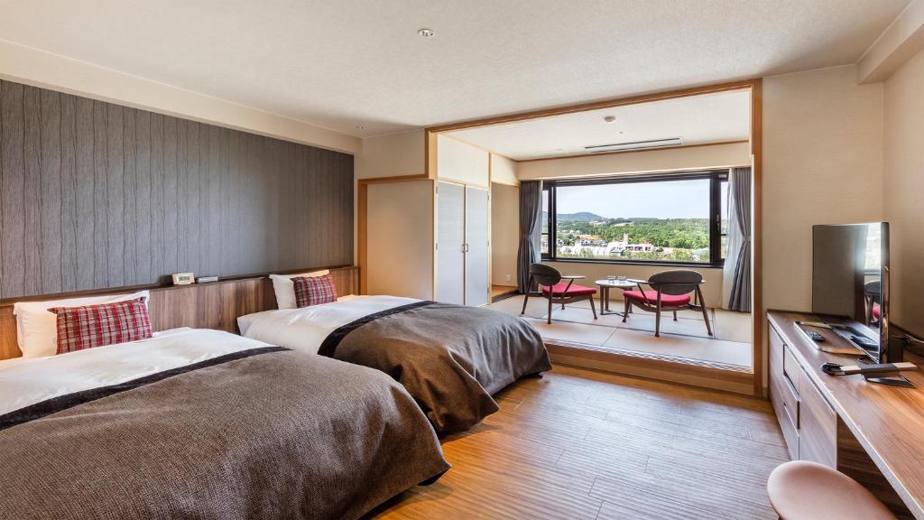 une chambre d'hôtel avec deux lits et un balcon dans l'établissement Kiki Shiretoko Natural Resort, à Shari 37 autres photos