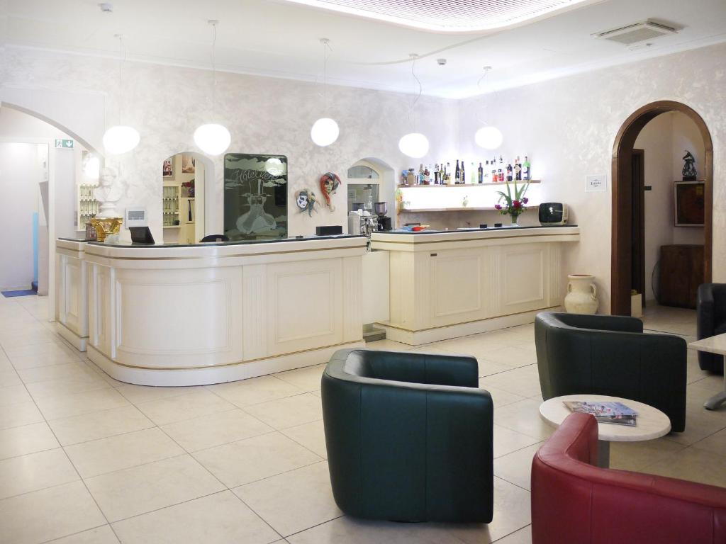 un salon avec un comptoir et des chaises dans la pièce dans l'établissement Hotel Verdi, à Lido di Jesolo 123 autres photos