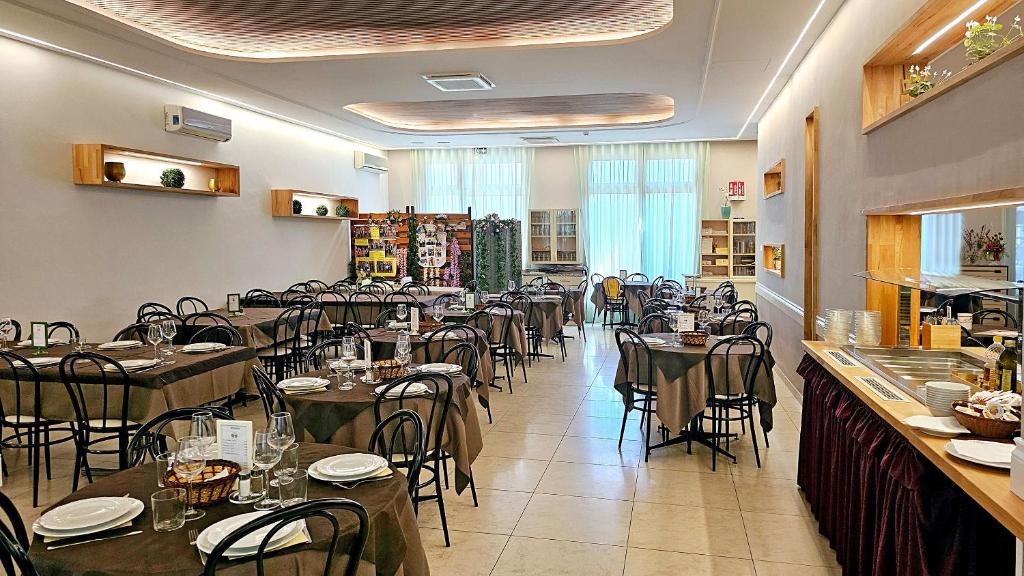 un restaurant avec des tables et des chaises dans une salle dans l'établissement Hotel Verdi, à Lido di Jesolo